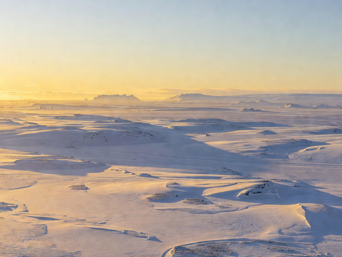 Atmospheric golden hour light stretching across calm polar terrain